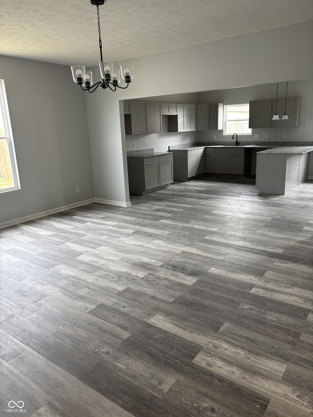 1433 Wigwam Ln, Martinsville, IN 46151 - kitchen with a sink, a chandelier, dark wood-style flooring, a textured ceiling, and baseboards