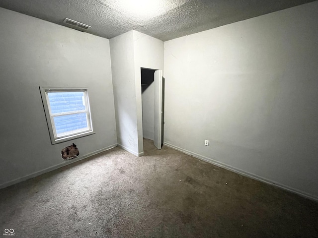 unfurnished room featuring a textured ceiling