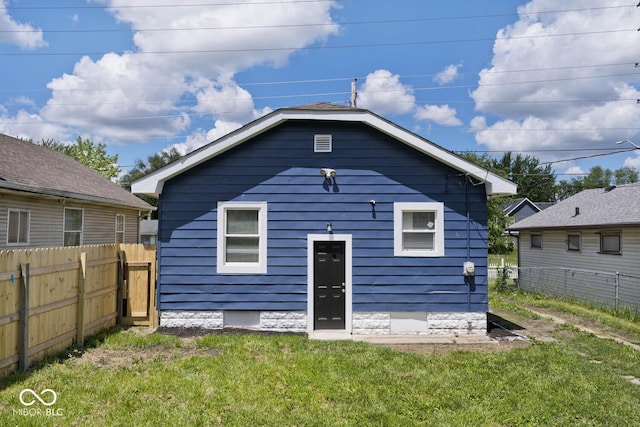 rear view of house featuring a yard