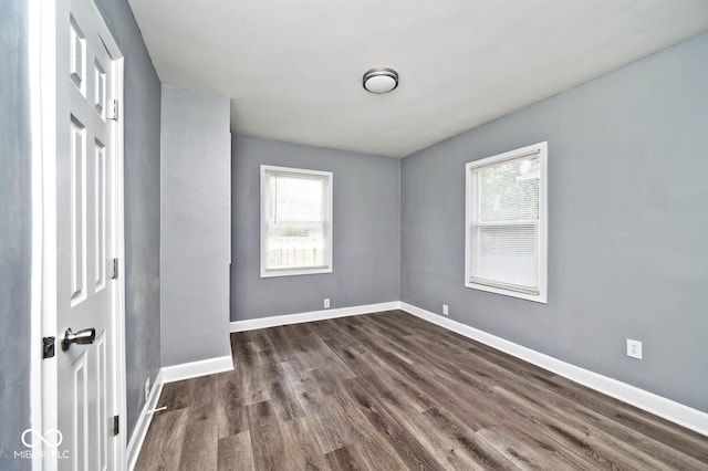 empty room with dark hardwood / wood-style flooring