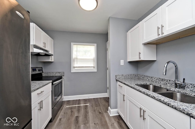 kitchen featuring light stone countertops, stainless steel appliances, sink, white cabinets, and hardwood / wood-style floors