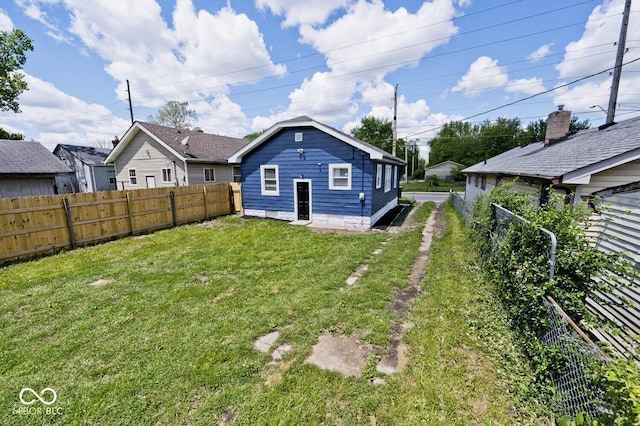 back of property with a lawn