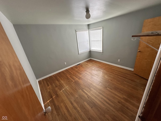 unfurnished room with dark hardwood / wood-style floors