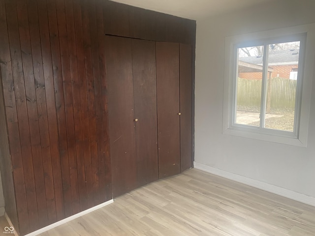 unfurnished bedroom featuring light hardwood / wood-style flooring and a closet