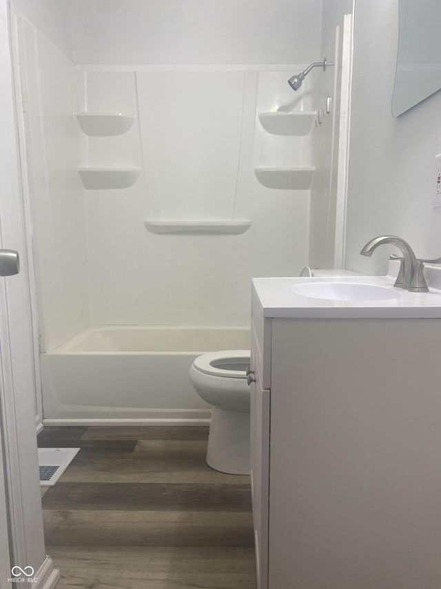 full bathroom with hardwood / wood-style floors, vanity, toilet, and washtub / shower combination