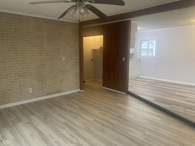 empty room with ceiling fan, crown molding, brick wall, and light hardwood / wood-style flooring