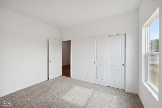 unfurnished bedroom featuring a closet, baseboards, and carpet floors