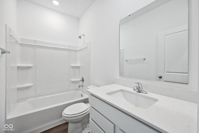 bathroom with vanity, wood finished floors, toilet, and tub / shower combination