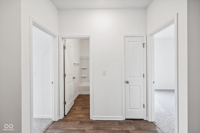 hallway featuring dark wood-style floors and baseboards