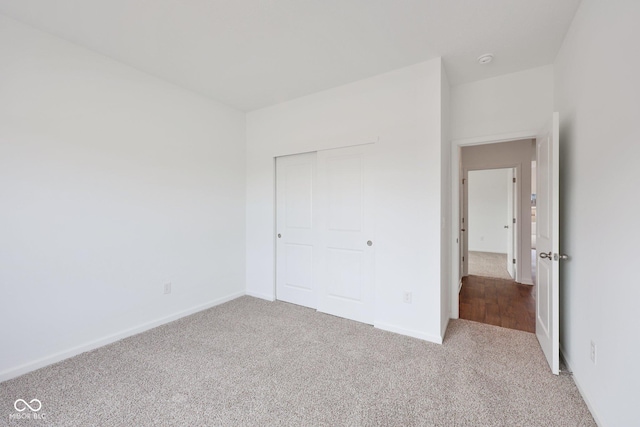 unfurnished bedroom featuring a closet, baseboards, and carpet