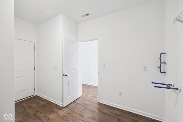 unfurnished bedroom with wood finished floors, visible vents, and baseboards