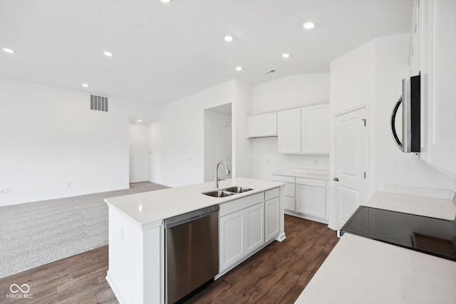 kitchen featuring visible vents, open floor plan, dishwasher, white cabinets, and a sink