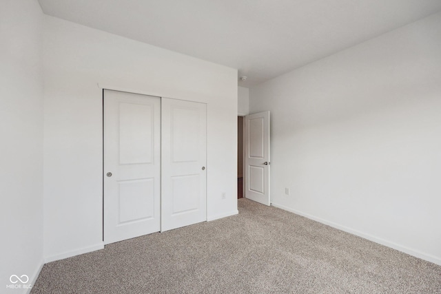 unfurnished bedroom featuring baseboards, a closet, and carpet floors