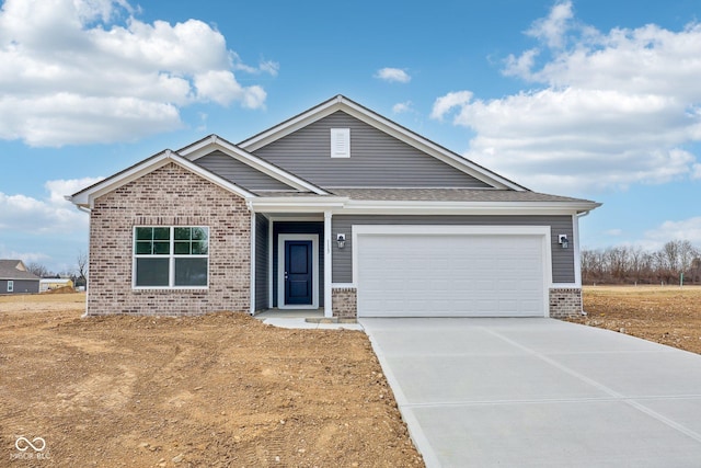 view of front of home featuring a garage, brick siding, concrete driveway, and a shingled roof