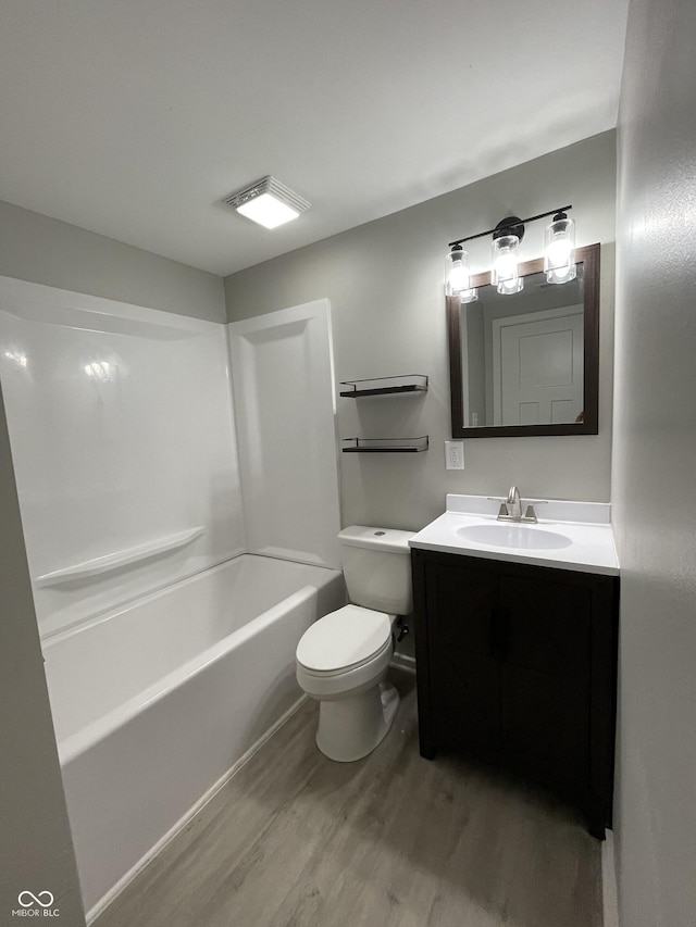 full bathroom with shower / bathing tub combination, hardwood / wood-style floors, vanity, and toilet