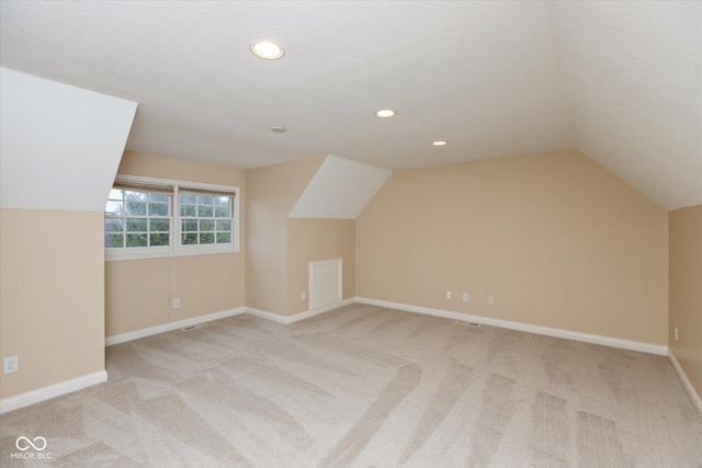 bonus room with light carpet, a textured ceiling, and vaulted ceiling