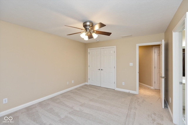 unfurnished bedroom with light carpet, a closet, and ceiling fan