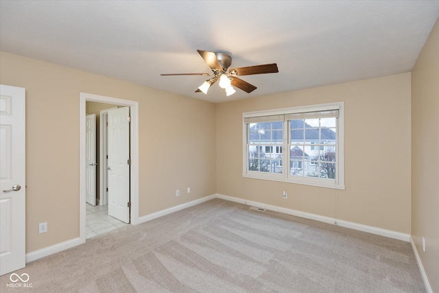 empty room featuring light colored carpet and ceiling fan