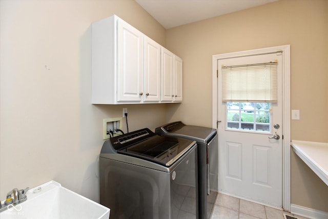 laundry area with washer and dryer, sink, light tile patterned floors, and cabinets