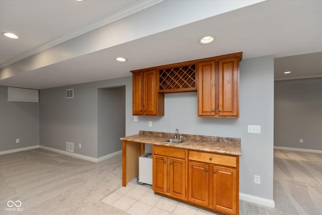 kitchen with ornamental molding, sink, and light carpet