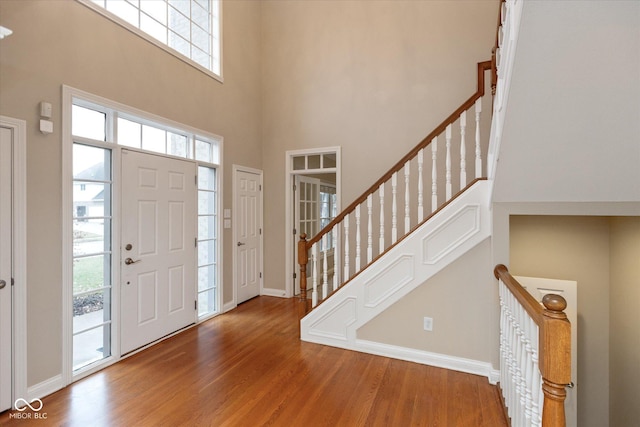 foyer featuring a healthy amount of sunlight, a high ceiling, and hardwood / wood-style flooring