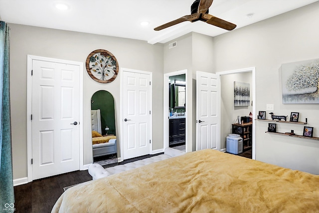 bedroom with ceiling fan, ensuite bathroom, and dark hardwood / wood-style floors