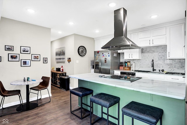 kitchen with island exhaust hood, stainless steel fridge, a breakfast bar, and white cabinets