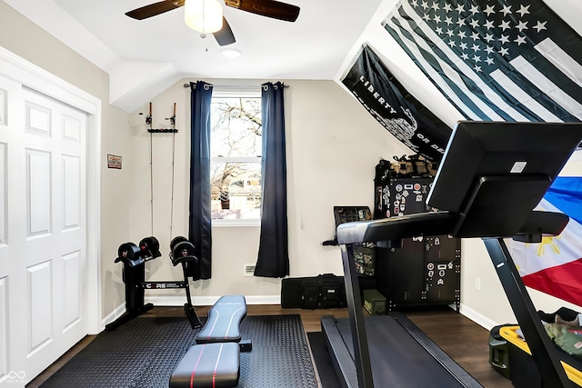 exercise area featuring vaulted ceiling, ceiling fan, and dark wood-type flooring