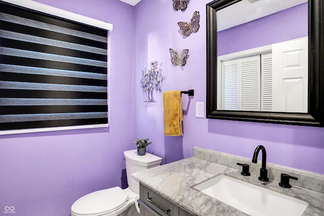 bathroom featuring vanity and toilet