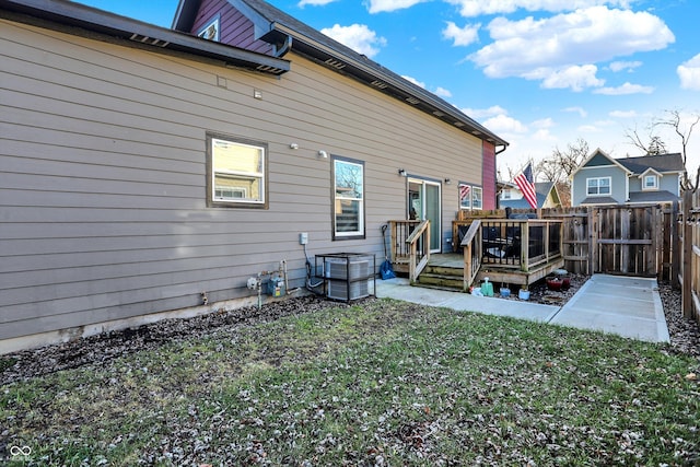 rear view of house featuring a yard and a wooden deck