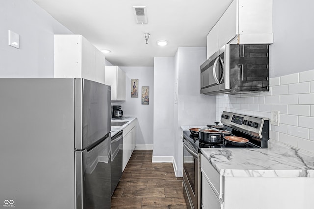 kitchen with backsplash, white cabinetry, and appliances with stainless steel finishes