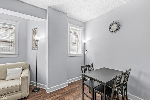 dining area featuring dark hardwood / wood-style floors and a textured ceiling