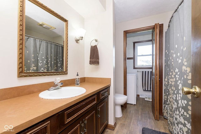 bathroom with toilet, vanity, and hardwood / wood-style flooring