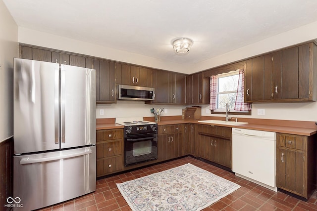 kitchen with dark brown cabinetry, stainless steel appliances, and sink