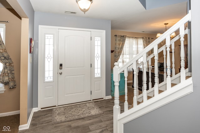 foyer with dark hardwood / wood-style flooring and an inviting chandelier