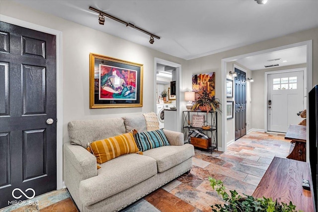 living room with rail lighting and washer / clothes dryer