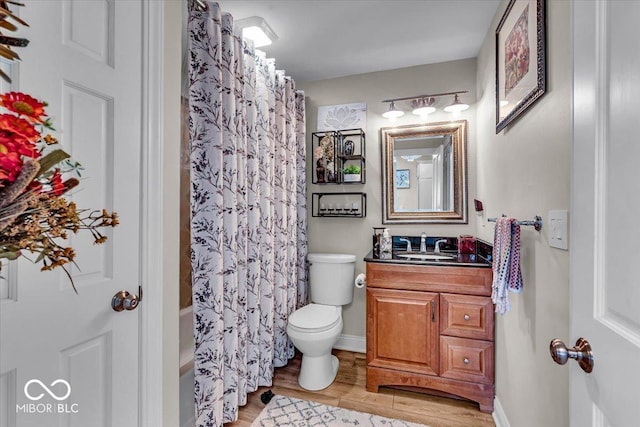 full bathroom with hardwood / wood-style flooring, vanity, toilet, and shower / bathtub combination with curtain