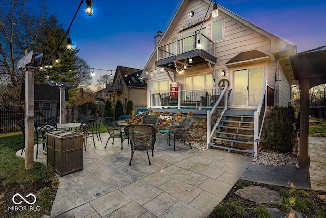 2222 E 75th St, Indianapolis, IN 46240 - back of property at dusk with a balcony, fence, and a patio
