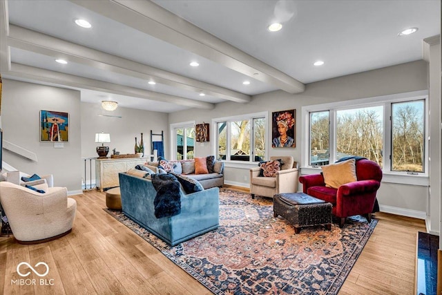 living room with beamed ceiling, light hardwood / wood-style flooring, and a healthy amount of sunlight