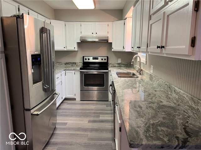 kitchen with light stone countertops, sink, white cabinetry, and stainless steel appliances