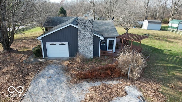 view of outdoor structure featuring a pergola, a garage, and a yard