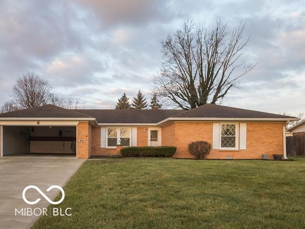 ranch-style home featuring a garage and a front lawn