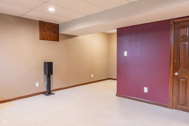 basement featuring light carpet and a drop ceiling