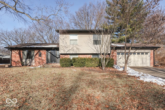 tri-level home featuring a garage and a front yard