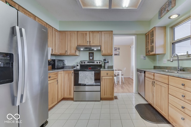 kitchen with stainless steel appliances, light tile patterned flooring, sink, and light brown cabinets