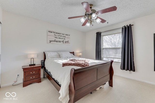 bedroom featuring ceiling fan, light colored carpet, and a textured ceiling