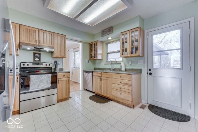 kitchen with light tile patterned flooring, appliances with stainless steel finishes, light brown cabinetry, and sink