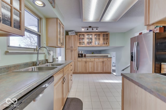 kitchen with stainless steel refrigerator with ice dispenser, light brown cabinetry, sink, light tile patterned floors, and white dishwasher