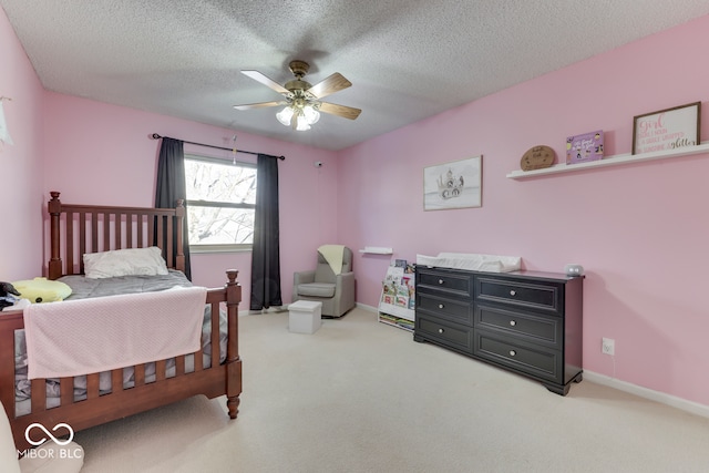 bedroom with ceiling fan, carpet, and a textured ceiling