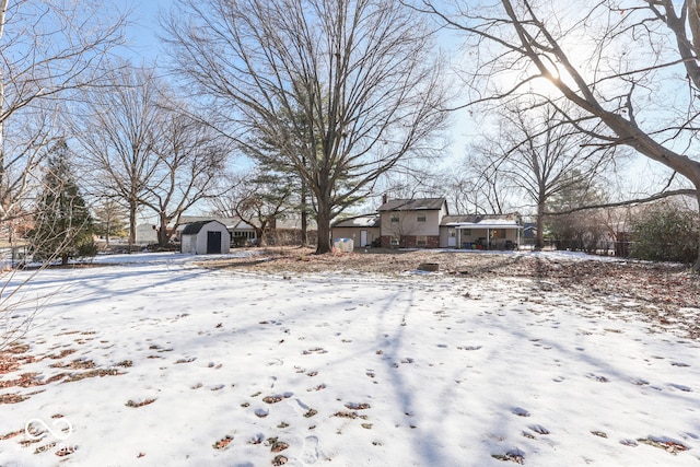 yard layered in snow with a storage shed